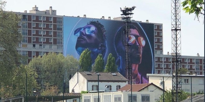Un géant poster de \'\'Deux Frères\'\' de PNL accroché sur un immeuble dans la cité de leur enfance