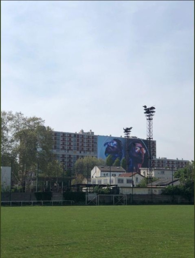 Un géant poster de ''Deux Frères'' de PNL accroché sur un immeuble dans la cité de leur enfance