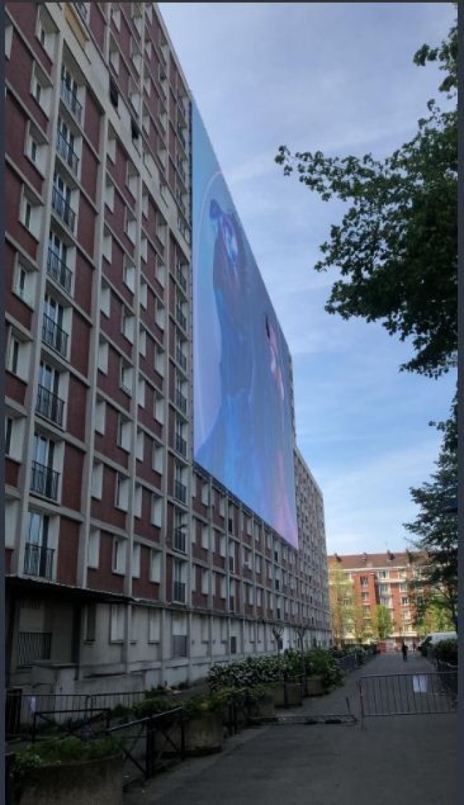 Un géant poster de ''Deux Frères'' de PNL accroché sur un immeuble dans la cité de leur enfance