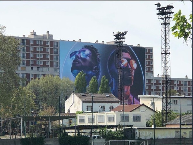 Un géant poster de ''Deux Frères'' de PNL accroché sur un immeuble dans la cité de leur enfance